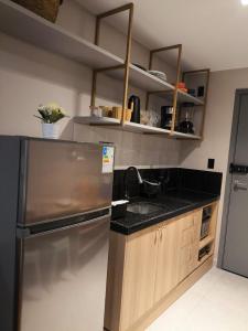 a kitchen with a stainless steel refrigerator and a sink at Flat 4 Mares - Refugio a dois - Com piscina e estacionamento em Intermares in Cabedelo