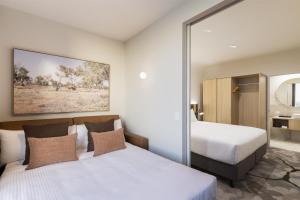 a hotel room with two beds and a mirror at Adina Chermside Brisbane in Brisbane +85 photos
