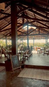 two people sitting at tables in a pavilion at Lexias Hostel and Workspace - Siargao in Catagnan