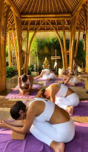 a group of people doing yoga in a pavilion at Rumah Kita Ecolodge in Ubud +23 photos