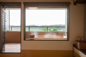a bathroom window with a view of a bath tub at Yutorelo Yamaga in Yamaga