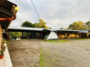 a building with a large yard in front of it at Cabinas del Río in Upala