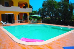 a swimming pool in front of a house at Happy Holiday Villa in Siracusa
