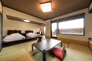 a room with a bed and a table and a window at Yutorelo Yamaga in Yamaga