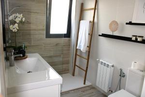 a white bathroom with a sink and a shower at Casa da Fonteseca a pie de playa in Ribeira +14 photos