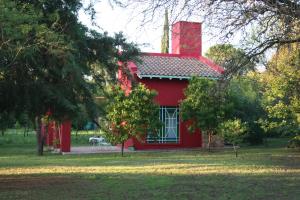 a red house with a window in a park at Raco De La Calma in Nono