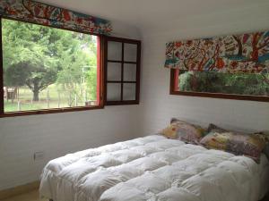 Cama grande en habitación con 2 ventanas en Raco De La Calma en Nono