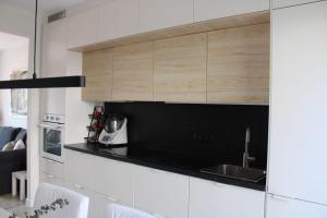 a kitchen with white cabinets and a black counter top at Casa da Fonteseca a pie de playa in Ribeira
