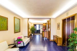 a hallway with couches and plants in a building at Residence Villa Chiara in Loano