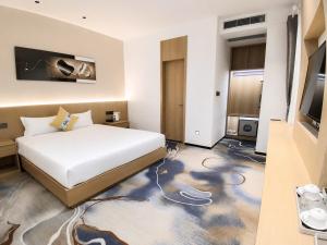 a hotel room with a bed and a television at Kim Thành Hotel in Bắc Ninh