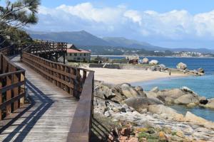a wooden bridge over a body of water at Casa da Fonteseca a pie de playa in Ribeira
