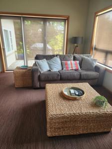 a living room with a couch and a table at Te Moana Delight in Waikanae
