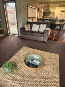 a living room with a remote control on a rug at Te Moana Delight in Waikanae +18 photos