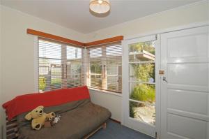 a bedroom with a bed with a teddy bear on it at Te Moana Delight in Waikanae