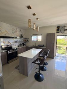 a kitchen with a large island with two bar stools at Suite Seven in Mount Pleasant