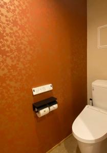 a bathroom with a toilet and two rolls of toilet paper at Besso城前 in Himeji