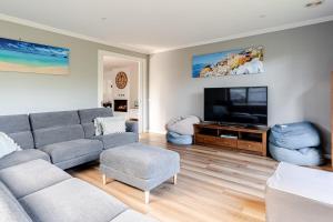 a living room with a couch and a flat screen tv at Luxury Capel Sound in Rye