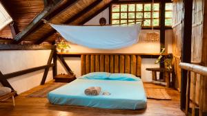 a room with a bed with a hammock in it at La Caleta House in Mompiche