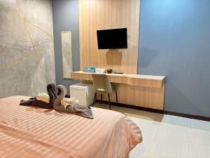 a bedroom with a bed and a desk with a television at Le Park 23 Boutique Resort in Roi Et