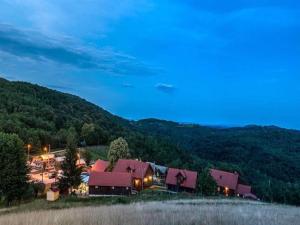 a building with red roofs in front of a mountain at Nature Escape with Pool & Garden Views in Karlovac +8 photos