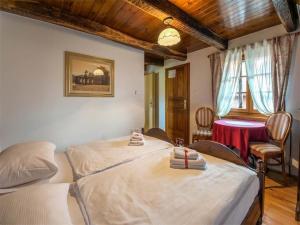 two beds in a room with a table and chairs at Nature Escape with Pool & Garden Views in Karlovac