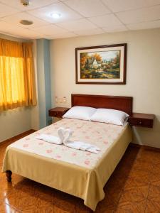 a bedroom with a bed with two towels on it at Hotel Milenio in Guayaquil