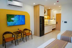 a room with a table and chairs and a kitchen at Homestay The Pathway Sầm Sơn in Sầm Sơn