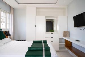 a bedroom with a white bed with a green blanket on it at Kingston Horizon Retreat in Kingston