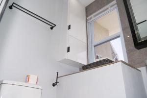 a bathroom with a window above a toilet at Kingston Horizon Retreat in Kingston +14 photos