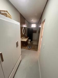 a hallway of a bathroom with a toilet and a sink at New progress, it's Félix! in Marabá +1 photo