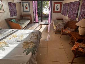 a bedroom with a bed and a couch and chairs at Kukuriaz Fare in Bora Bora