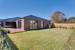 a brick house with a lawn in front of it at Luxury Capel Sound in Rye