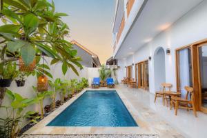 an indoor swimming pool in a house with plants at Kubu YN Bali in Jimbaran