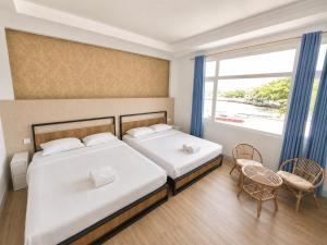 a bedroom with two beds and a large window at Allisa Resort Hotel in Anyer