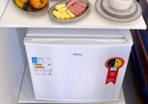 a white refrigerator with food on top of it at São Gabriel Centro Studios & Suítes in São Gabriel