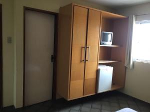Cette chambre comprend une armoire avec un four micro-ondes et un réfrigérateur. dans l'établissement Hotel Santa Inez, à Nazareth