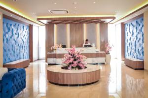 a lobby of a hotel with a woman in the background at Hexton Hotel Lampung in Tanjungkarang