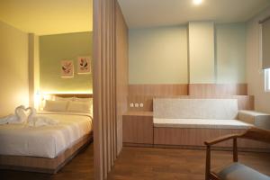 a bedroom with a bed and a bench in it at Hexton Hotel Lampung in Tanjungkarang +14 photos