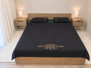 a bedroom with a black bed with two night stands at РАДУГА Иссык-Куль in Chon-Sary-Oy +46 photos