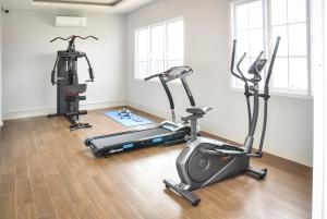 a gym with two treadmills and two exercise bikes at Hexton Hotel Lampung in Tanjungkarang
