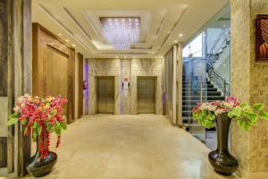 a hallway with two vases with flowers in them at Super Townhouse Oak Hotel C Pearls in New Delhi