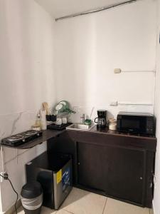 a small kitchen with a counter with a microwave at Marena paradise, loft escondido,wifi,piscina12 in La Libertad