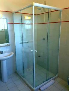 a glass shower in a bathroom with a sink at Plaza Center Hotel in São Lourenço do Sul