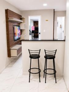 two bar stools sitting at a counter in a kitchen at House Pontal do Paraná in Pontal do Paraná