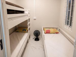 a small room with bunk beds and a fan at House Pontal do Paraná in Pontal do Paraná