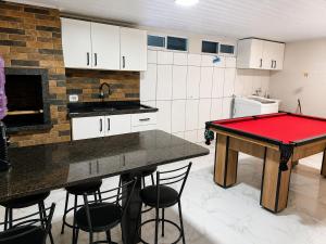 a kitchen with a red ping pong table in it at House Pontal do Paraná in Pontal do Paraná
