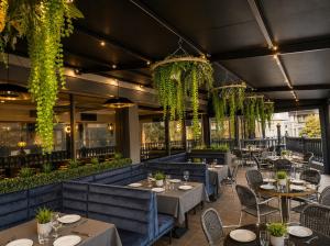 a restaurant with tables and chairs and vines at Crest on Barkly Hotel in Melbourne