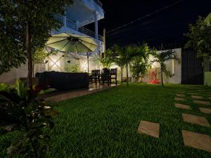 a backyard at night with an umbrella in the yard at Little Heaven Villa in Lomé