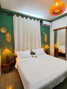 a bedroom with a large white bed and green walls at Little Heaven Villa in Lomé
