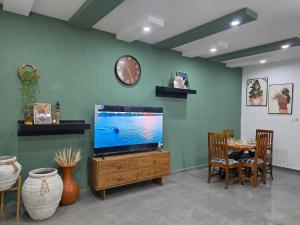 a living room with a flat screen tv on a wooden entertainment center at Little Heaven Villa in Lomé
